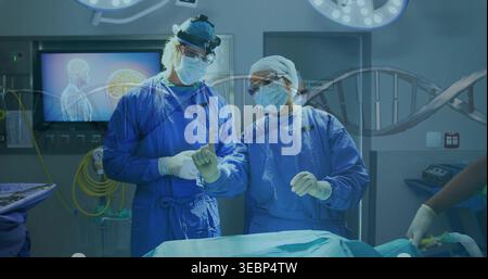 Standing surgeons discussing procedure in OR, using headlamp and viewing brain monitor DNA overlay Stock Photo
