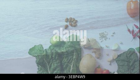 Laying dark leafy greens on pale wood surface with faint water overlay, showing potato, ginger Stock Photo
