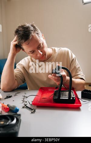 Thoughtful technician person performing computer cooling system maintenance, disassembling liquid cooler components for cleaning and repair, focusing Stock Photo