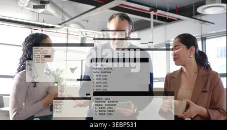 Meeting team of three around tablet in office, wearing blazer, holding mugs, code overlay Stock Photo