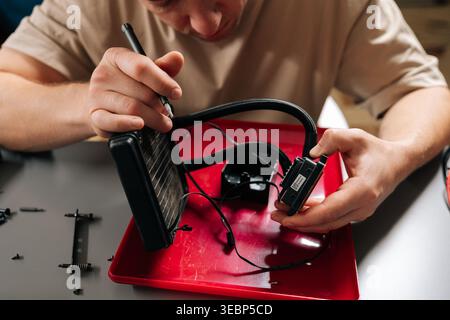 Top view of technician man performing computer cooling system maintenance, repairing all-in-one liquid cooler, servicing electronics hardware for Stock Photo