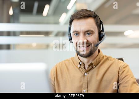Male professional working in an office with a headset, providing help desk assistance and customer service, representing concepts of communication, support, and business Stock Photo