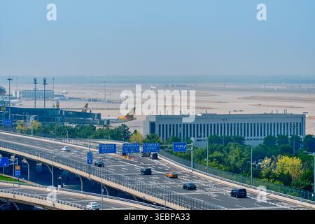BEIJING, CHINA - May 27, 2025: Transport infrastructure at PKX airport showing elevated roads cars trucks and runways in background Stock Photo