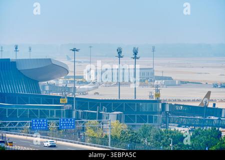 BEIJING, CHINA - May 27, 2025: Transport infrastructure at PKX airport showing elevated roads cars trucks and runways in background Stock Photo