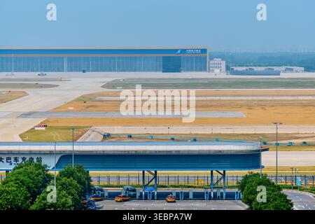BEIJING, CHINA - May 27, 2025: Transport infrastructure at PKX airport showing elevated roads cars trucks and runways in background Stock Photo