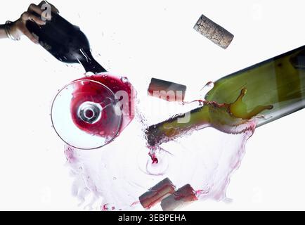 Red wine splash with bottle corks and glass top view isolated on white background Stock Photo