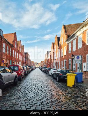 Cobblestone street in the Dutch Quarter. Wide view of the Holländisches Viertel with red brick houses with gabled roofs along cobblestone road. Stock Photo