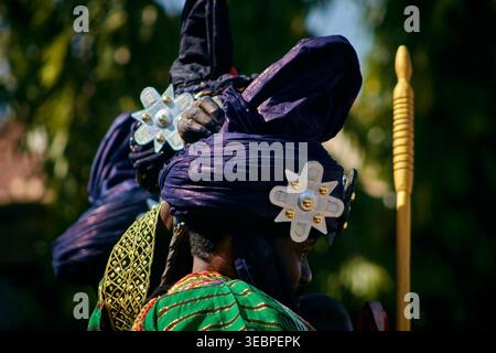 Zaria city, Nigeria - 21 March 2026: View of a figure in a deep blue turban with gleaming silver stars, contrasting vibrant green and gold traditional Stock Photo
