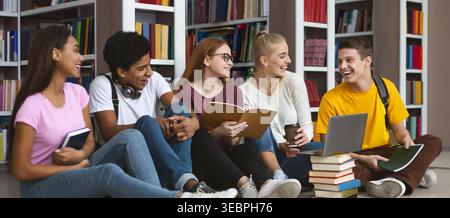 Group of Students Studying and Discussing Together in a Modern Library Setting Stock Photo