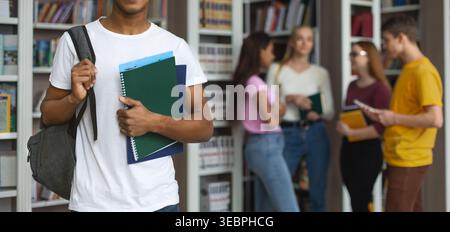 Students Engaging in Study Session Inside a Library Filled With Books in the Afternoon Stock Photo