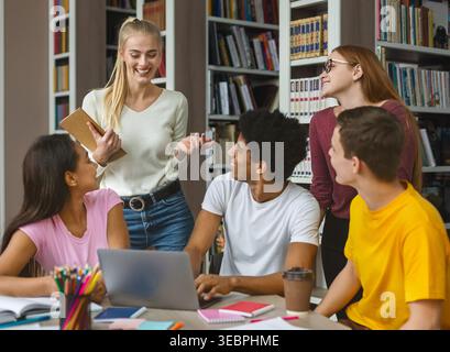 Group of Students Collaborating and Discussing Projects in a Library Setting Stock Photo