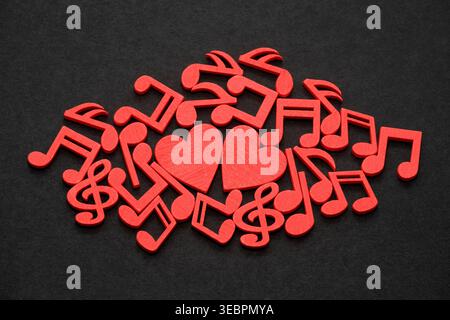 Two red hearts with red musical notes on black background Stock Photo