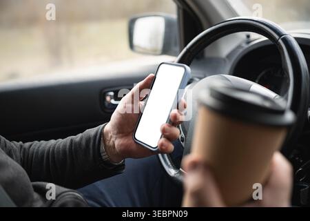 Driver Holding Smartphone And Coffee Cup While Driving Stock Photo