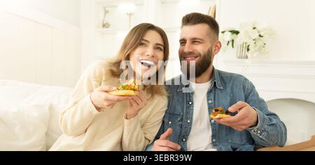 Happy Couple Eating Pizza And Laughing At Home Stock Photo