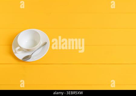 Empty White Cup with Spoon on Yellow Wooden Background Stock Photo