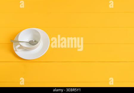 Empty White Cup with Spoon on Yellow Wooden Background Stock Photo