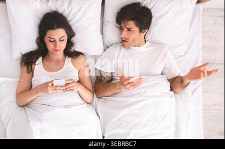 Couple Having a Serious Conversation About Their Relationship in Bed at Home Stock Photo