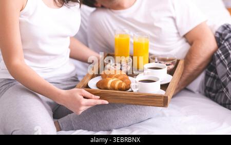 Couples Enjoy Breakfast in Bed With Fresh Pastries and Beverages on a Cozy Morning Stock Photo