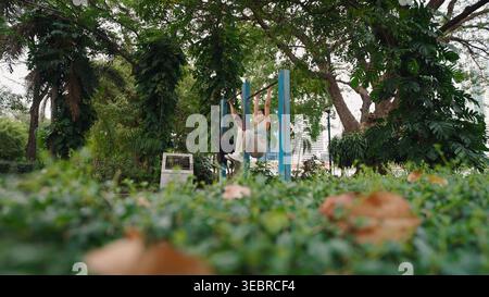 Fitness couple exercising together outdoors doing leg raises and strengthening abs Stock Photo