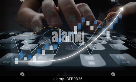 A close-up image showcasing hands working on a computer keyboard while analyzing financial data, complemented by stock market graphs for a business Stock Photo