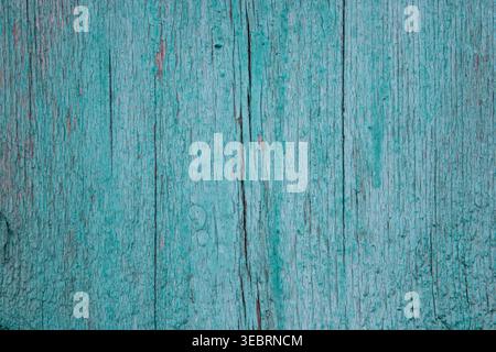 Weathered turquoise wood texture with peeling paint and deep vertical cracks, showcasing an authentic rustic aesthetic ideal for vintage-them Stock Photo