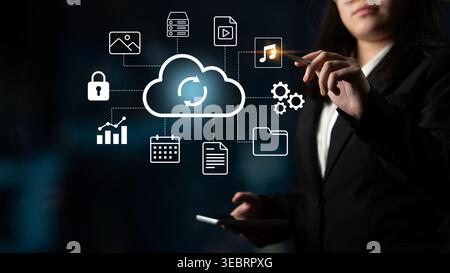 A businesswoman engages with cloud technology icons representing data storage and digital solutions in a modern workplace, showcasing innovation and Stock Photo