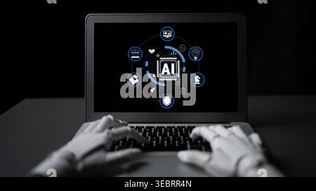 Hands of a robotic assistant typing on a laptop displaying artificial intelligence icons in a dark environment, showcasing technology and innovation Stock Photo