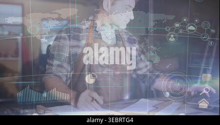 Leaning mature man in plaid shirt and leather apron sketching plans at workshop, with AR overlays Stock Photo