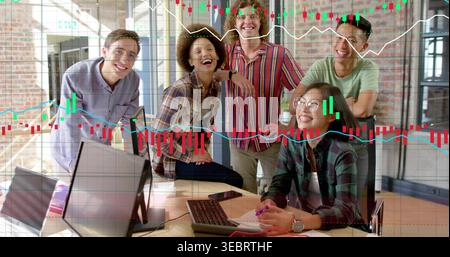 Laughing team of five in plaid striped shirts working at office laptops, finance charts overlaying Stock Photo
