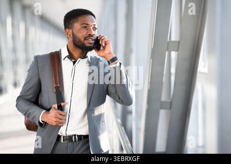 Businessman in Suit Engaged in Phone Conversation in Modern Office Setting Stock Photo