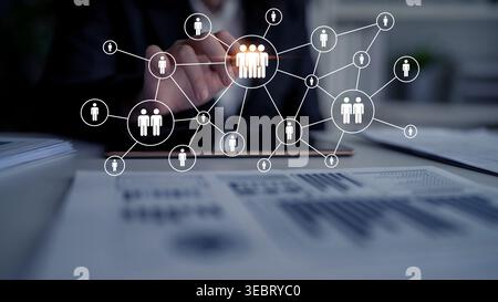 A business professional uses a tablet to connect with a digital network of people icons, symbolizing modern communication and data-driven Stock Photo