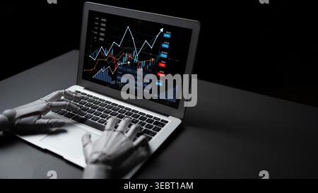 A robotic hand engages with a laptop displaying dynamic financial graphs. This image showcases the intersection of technology and finance in a modern Stock Photo