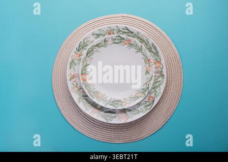 Overhead shot of christmas themed plates on top of each other on a woven mat. Light is soft, shadows are subtle. Background is clean and focus is shar Stock Photo