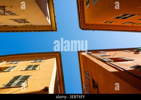France, Nice, exterior view of ochre coloured buildings, four corners of buildings looking up to a blue sky Stock Photo