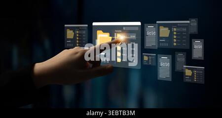A person interacts with a sleek digital interface that displays virtual files and folders, showcasing advanced technology in modern data management Stock Photo