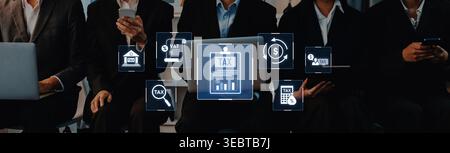 A group of business professionals collaborates in a modern office setting, utilizing digital tools to assist with tax preparation and financial Stock Photo