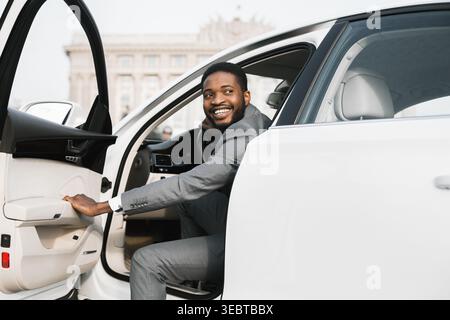 Smartly Dressed Man Exiting a Luxury Car in an Urban Setting Stock Photo