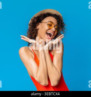 Happy Young Woman in Swimsuit Enjoying Summer Against Bright Blue Background Stock Photo