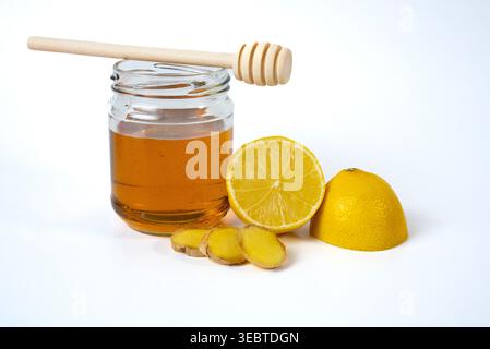 Honey jar with lemon and ginger on white background. Natural immunity booster and healthy tea ingredients.  Stock Photo