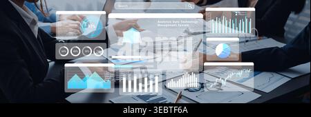 A dynamic office scene showing business professionals engaged in collaboration using a data management system, with digital charts and graphs Stock Photo