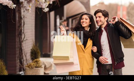 Couple Enjoying a Shopping Spree on a Sunny Day in an Urban Setting Stock Photo