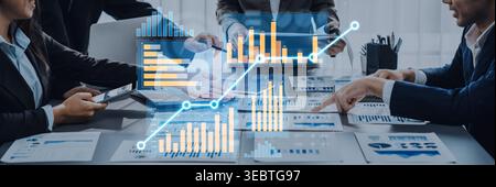 Teams work together in a modern office, analyzing data and financial reports. Professionals discuss insights and strategies for successful business Stock Photo