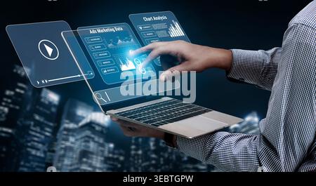 Futuristic Businessman Using Laptop to Analyze Marketing Data with Interactive Touchscreen Interface in Urban Night Setting Quark. Stock Photo