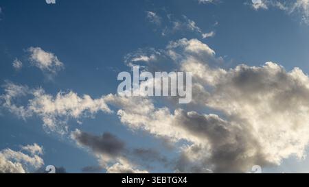Dramatic cloudscape with cumulus and stratocumulus clouds against blue sky Stock Photo