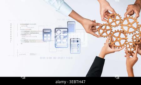 A dynamic image illustrating hands collaborating around wooden gears, symbolizing teamwork and innovation in technology against a backdrop of coding Stock Photo