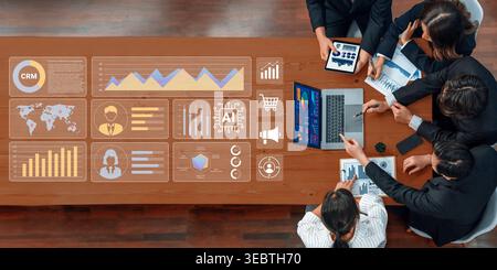 A diverse business team collaborates in a modern office setting, analyzing data and charts on laptops and digital displays, emphasizing teamwork and Stock Photo