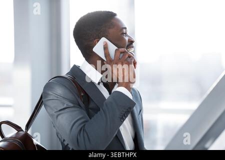 Travelling Businessman Making Phone Call, Arriving at Airport Stock Photo