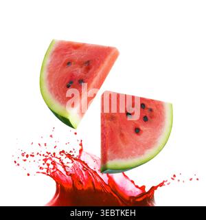 Fresh watermelon pieces falling into splashing juice on white background Stock Photo