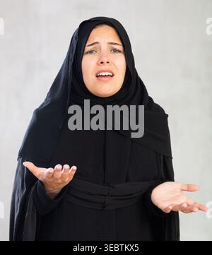 Worried young woman dressed in traditional islamic clothes Stock Photo