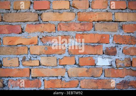 Old red brick wall texture. Background of a red brick wall, brick wall background. Stack of old, weathered bricks. Old broken brick. Construction and Stock Photo